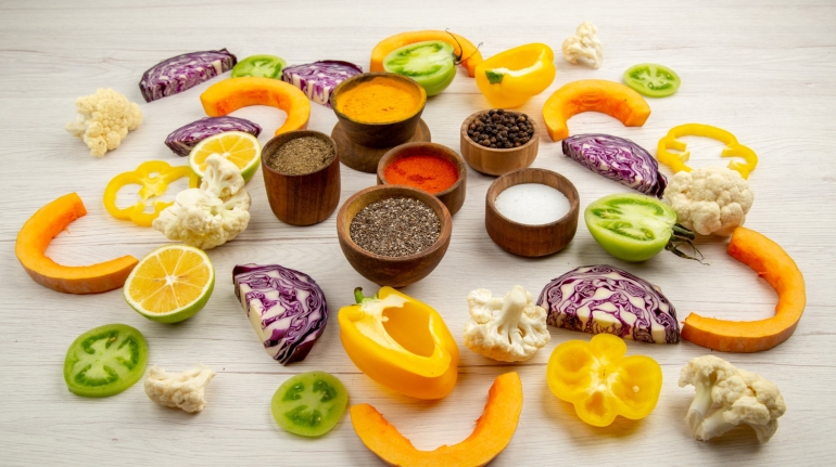 bottom-view-spices-bowls-cut-bell-pepper-cauliflower-cut-pumpkin-cut-red-cabbage-cut-green-tomatoes-table